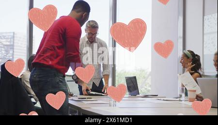 Image of pink hearts over diverse business people in office Stock Photo