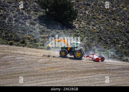 tractor in the field plowing and flattening the land for sowing Stock Photo