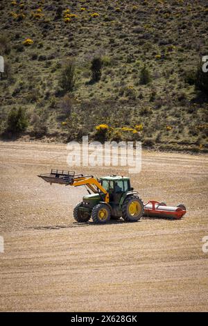 tractor in the field plowing and flattening the land for sowing Stock Photo