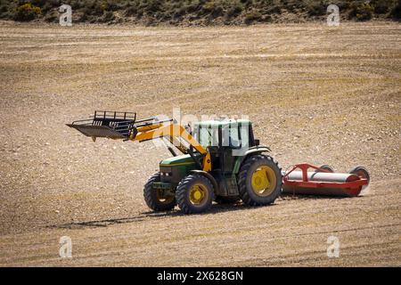 tractor in the field plowing and flattening the land for sowing Stock Photo