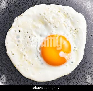 Close-up view of a freshly cooked fried egg on a nonstick skillet, perfect for breakfast themed imagery. Stock Photo