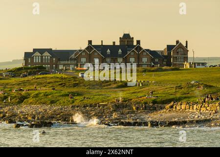 High tide and the Rest Home  is bathed in the warm light of sunset. Rest Bay, Porthcawl, UK. Stock Photo