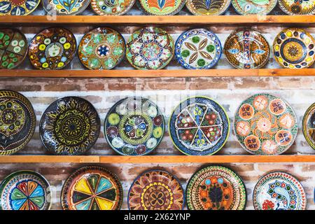 An assortment of handmade Uzbek plates with colorful traditional patterns are put up for sale at a street market in Bukhara Stock Photo