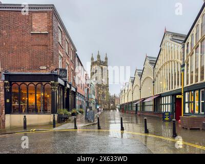 Stockport Market Hall with St Mary's Church in the distance on a grey wet day. Stock Photo