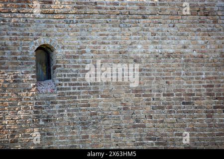 Broken stone texture on old grey wall with arched window in Tallinn. Background. Template. For design. Horizontal. Stock Photo