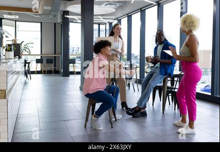 In modern office, diverse young team discussing Stock Photo