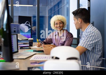In modern office, diverse young team wearing glasses, discussing Stock Photo