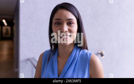 Middle-aged biracial woman smiling at camera at office Stock Photo