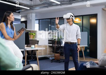 Caucasian woman with tablet, African American man in VR headset Stock Photo