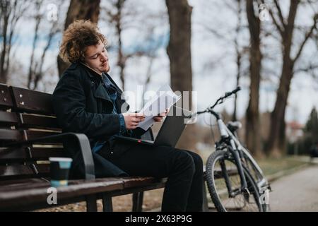 Business professional with a bicycle reviewing documents in a park Stock Photo