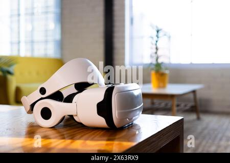At office, white virtual reality headset resting on table in bright room Stock Photo
