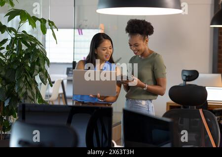 At office, diverse female business colleagues discussing work Stock Photo