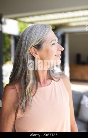 At home, Caucasian mature woman looking away, standing outdoors Stock Photo