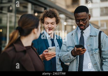 Business professionals in casual meeting outdoors, discussing over smart phones Stock Photo