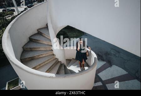 Professional woman on a phone call descending outdoor staircase Stock Photo