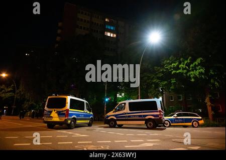 Hamburg, Germany. 13th May, 2024. Police emergency vehicles stand in front of a high-rise building in the Altona district after a person with a firearm triggered a large-scale operation. Credit: Jonas Walzberg/dpa/Alamy Live News Stock Photo