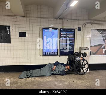 Disabled homeless man sleeps in a subway train station entrance by his ...