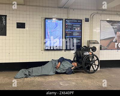 Disabled homeless man sleeps in a subway train station entrance by his ...