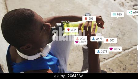 Image of multiple notification bars, overhead view of african american athlete drinking water Stock Photo
