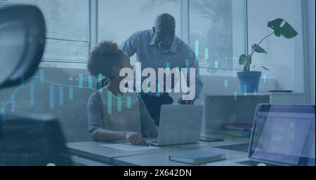 Image of graphs, loading circles, trading board, diverse coworkers discussing on desk in office Stock Photo