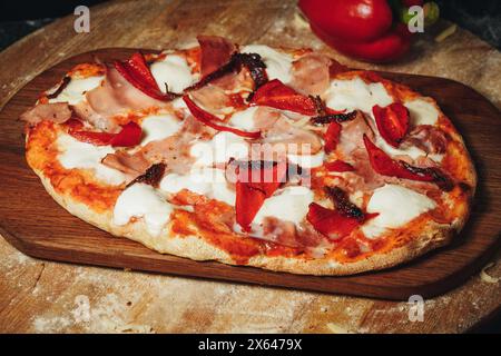 Savory Delight: Pizza on Wooden Cutting Board Stock Photo