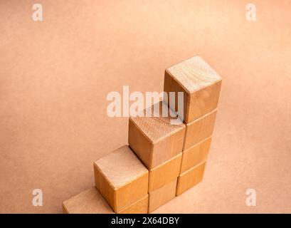 Blank wooden cube blocks bar graph chart four steps, isolated on brown recycle paper background, investment, income, inflation, business growth, econo Stock Photo