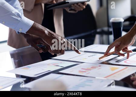 At office, diverse team reviewing business papers on table Stock Photo