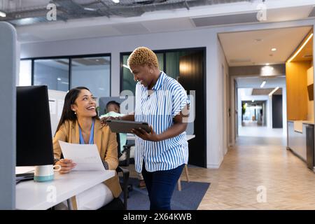 Diverse team discussing business documents at office, sharing happy moment Stock Photo