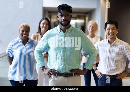 Diverse team standing together at office, all smiling Stock Photo
