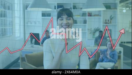 Image of illuminated graphs over smiling biracial woman standing in office Stock Photo