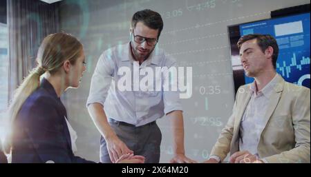 Image of graphs, loading circles and trading board over caucasian coworkers discussing in office Stock Photo