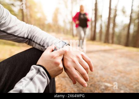 Close up of overweight woman running down the stairs, personal trainer checking her performance. Exercising outdoors for people with obesity, support Stock Photo