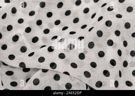 Polka dot fabric background, monochrome. Dotted textile pattern, black and white. Chiffon fabric. Fold satin background. Silk fabric background. Stock Photo
