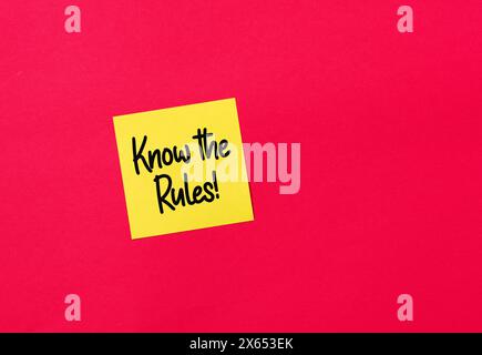 Know the rules message on a yellow sticky note paper on red background. Business regulations and rules concept. Stock Photo