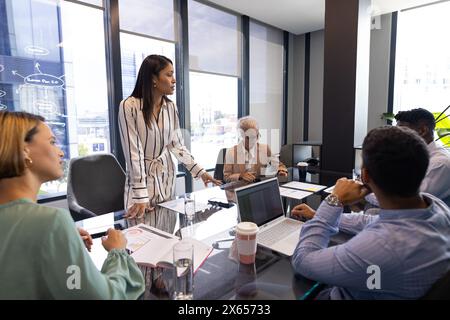 Diverse team discussing at office, biracial woman leading Stock Photo