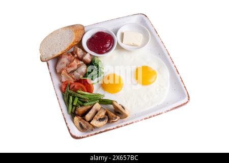 Breakfast Plate, Fried Eggs, Bacon, Roasted Mushrooms, Vegetables and Toppings on White Background Isolated Stock Photo