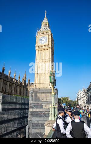 Big Ben at Palace of Westminster with Metropolitan police officers on beat patrol, London blue sky, England,UK,2023 Stock Photo