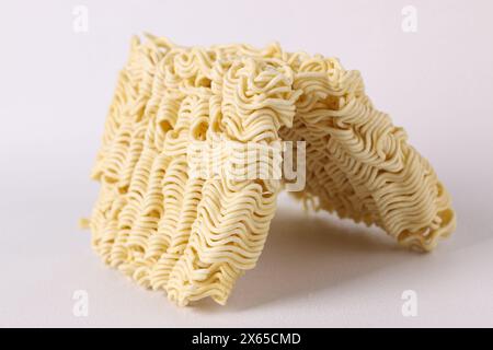 Dry uncooked instant noodles ramen with white background. Unhealthy food. Stock Photo