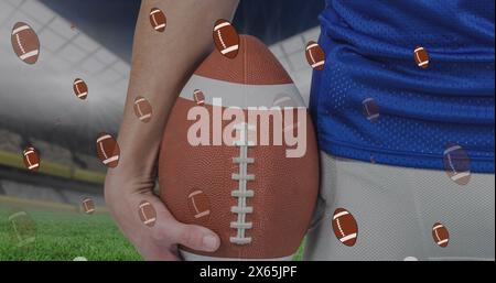 Image of rugby balls over caucasian male rugby player at stadium Stock Photo