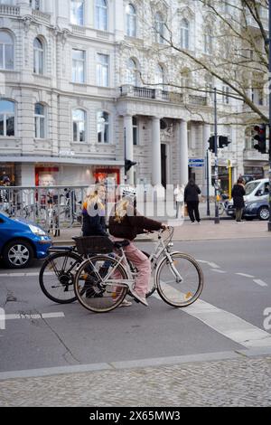 Women riding a bicycle on the road in Berlin. Stock Photo
