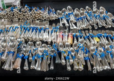 Silver cutlery sets knives forks and spoons displayed for sale on a table at a flea market or collectibles and antiques fair, UK Stock Photo