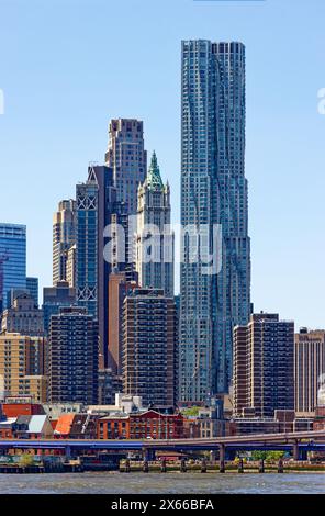 8 Spruce Street, formerly known as New York By Gehry, dominates this view of the Financial District, seen from Brooklyn Bridge Park. Stock Photo