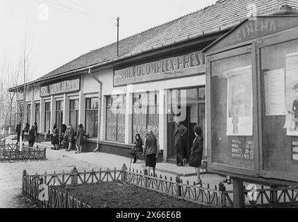 Socialist Republic of Romania in the 1970s. People staying in line in front of a state-owned grocery store, waiting for the delivery of food. The centralized socialist economic system created scarcity and hunger. Stock Photo