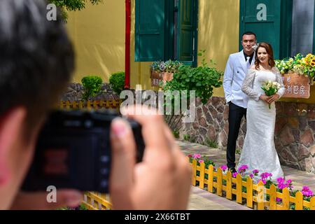 Yining, China's Xinjiang Uygur Autonomous Region. 10th May, 2024. Tourists pose for photos on the Liuxing Street in Yining City, Ili Kazak Autonomous Prefecture, northwest China's Xinjiang Uygur Autonomous Region, May 10, 2024. Credit: Ding Lei/Xinhua/Alamy Live News Stock Photo