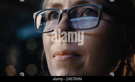 Close-up Portrait of Female Software Engineer Working on Computer, Programming Reflecting in Glasses. Developer Working on Innovative e-Commerce Application using Machine Learning, AI, Big Data Stock Photo
