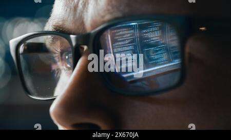 Close-up Portrait of Software Engineer Working on Computer, Line of Code Reflecting in Glasses. Developer Working on Innovative e-Commerce Application using Big Data Concept Stock Photo