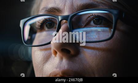 Close-up Portrait of Female Software Engineer Working on Computer, Programming Reflecting in Glasses. Developer Working on Innovative e-Commerce Application using Machine Learning, AI, Big Data Stock Photo