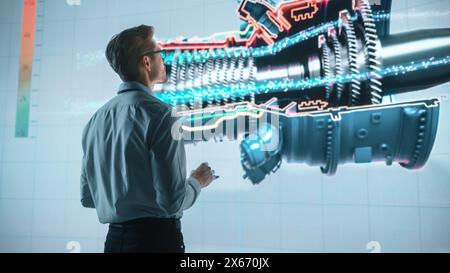 Innovative Green Energy Startup: Engineer Designing Engine Using Tablet Computer and Big Wall Screen to Analyse Prototype. Concept for Sustainable Environmnetally Friendly Zero Emissions Turbine Stock Photo