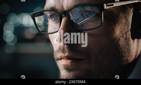 Close-up Portrait of Software Engineer Working on Computer, Line of Code Reflecting in Glasses. Developer Working on Innovative e-Commerce Application using Machine Learning, AI Algorithm, Big Data Stock Photo