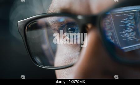 Close-up Portrait of Software Engineer Working on Computer, Line of Code Reflecting in Glasses. Developer Working on Innovative e-Commerce Application using Machine Learning, AI Algorithm, Big Data Stock Photo